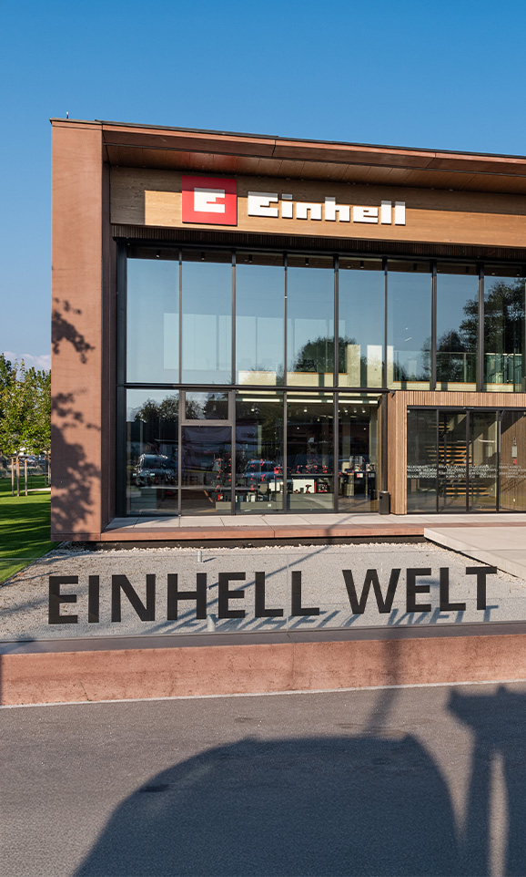 Einhell World: en modern företagsbyggnad med Einhell-logotypen och en stor grupp anställda.