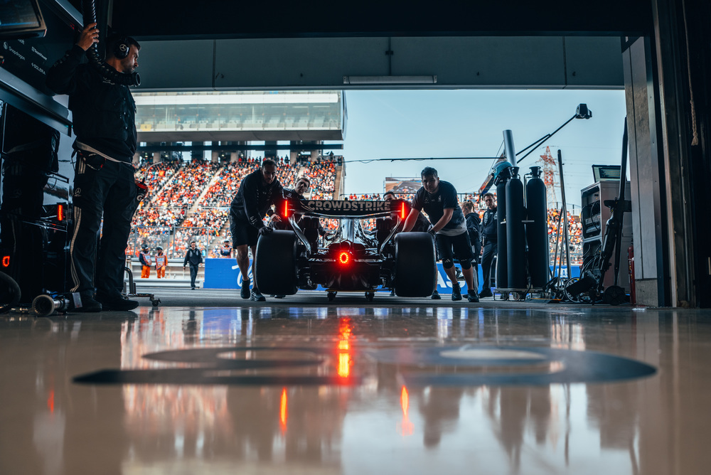 Mercedes F1 car in garage with equipment and lights